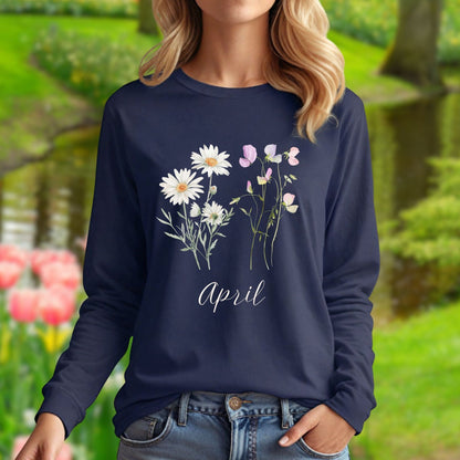 Navy long-sleeve tee with white daisies, pink sweet peas, and "April" script, worn by a woman in a garden.