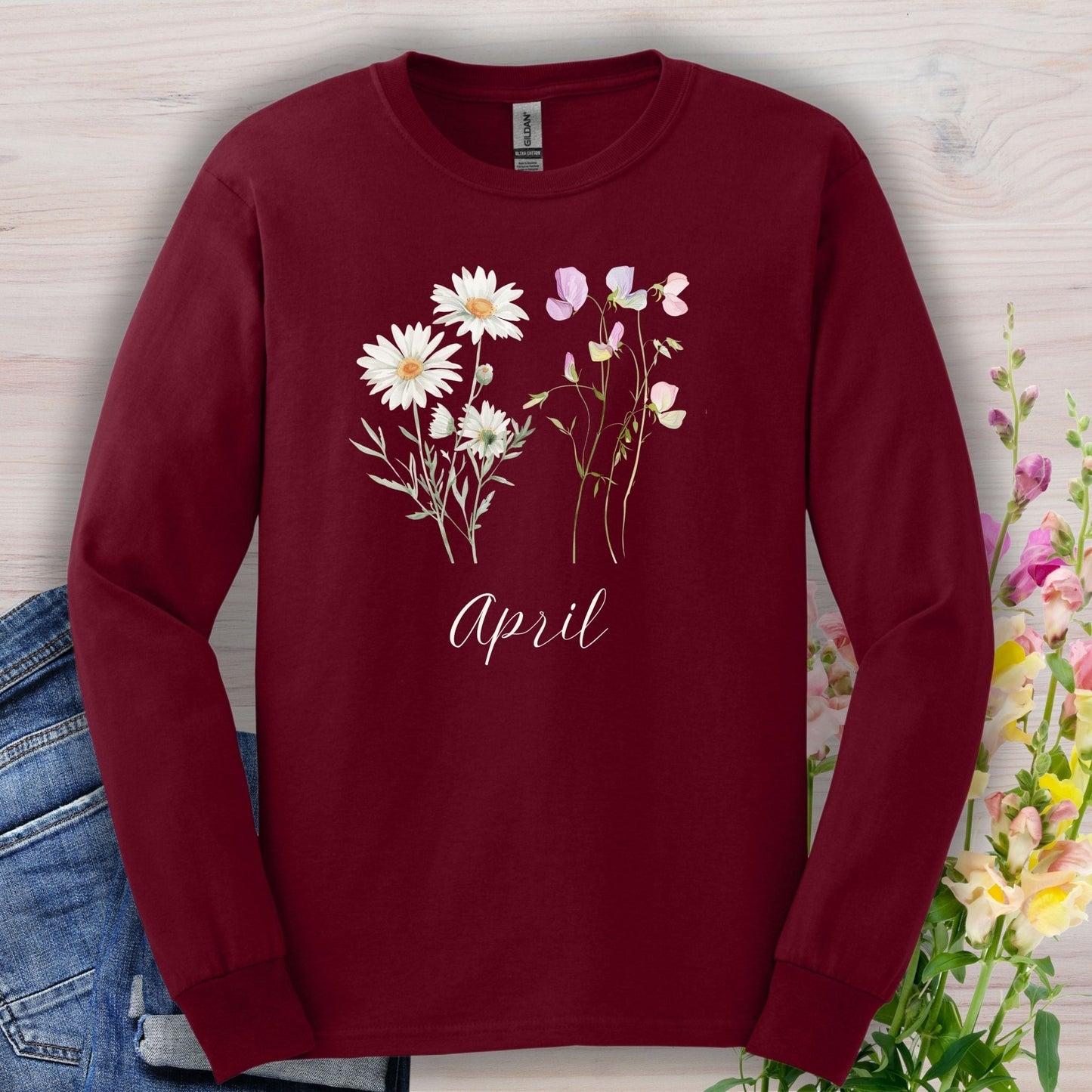 Maroon long-sleeve tee with hand-drawn daisies, sweet peas, and "April" script.
