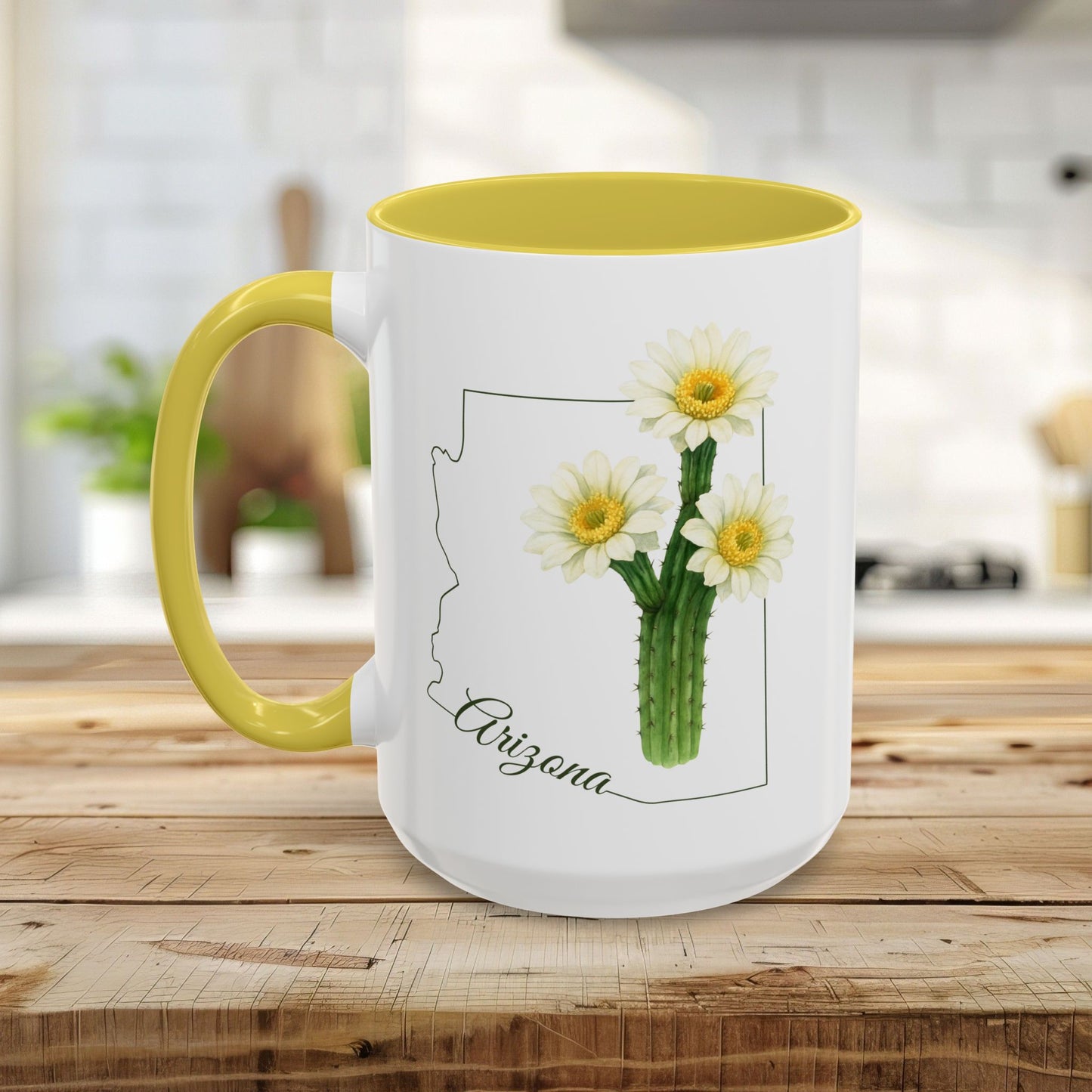 White ceramic mug with yellow handle and interior, featuring a blooming saguaro cactus design within an Arizona outline.