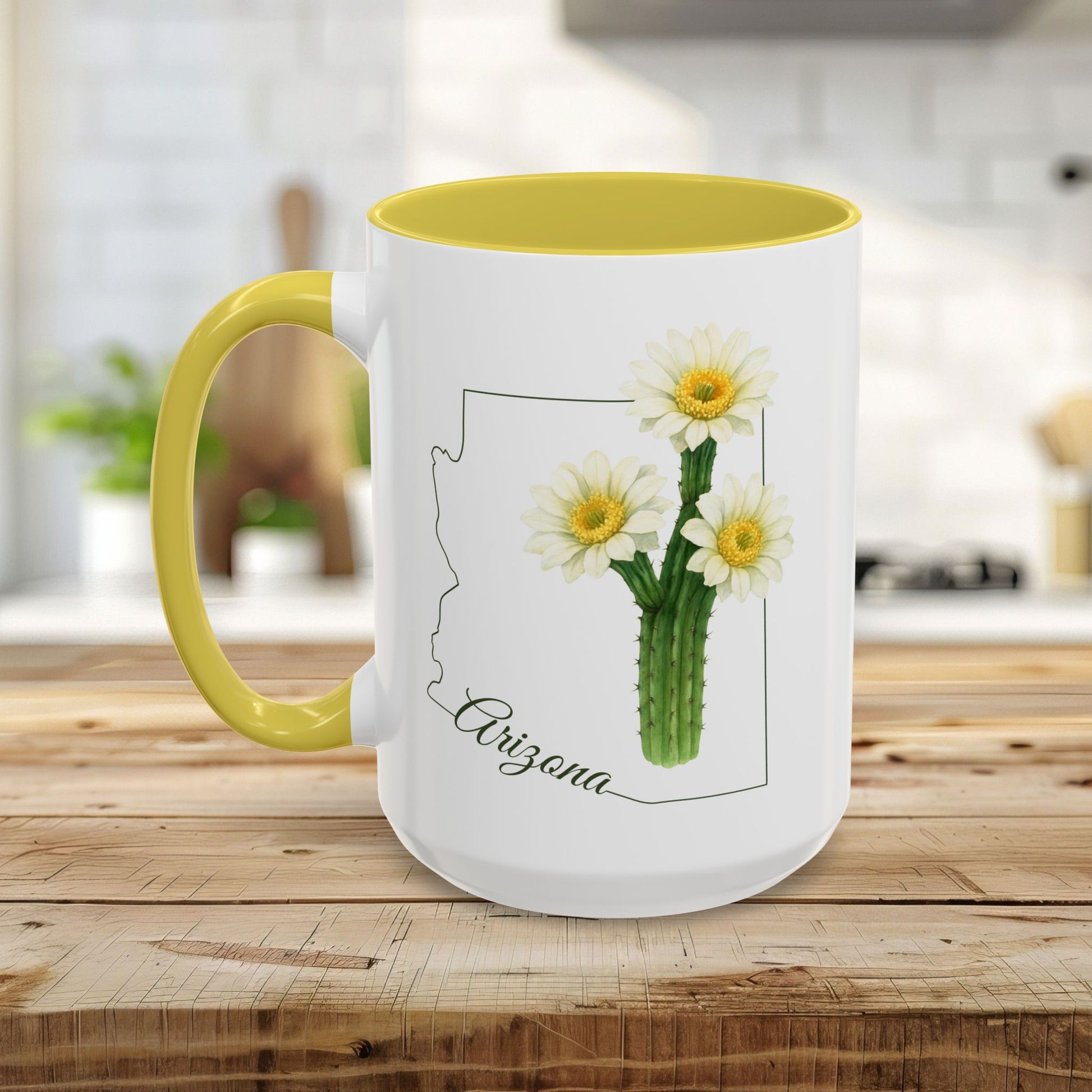 White ceramic mug with yellow handle and interior, featuring a blooming saguaro cactus design within an Arizona outline.