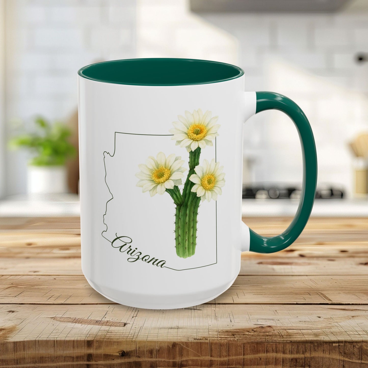 White ceramic 11oz mug with green handle/interior, featuring an Arizona outline and blooming saguaro cactus.