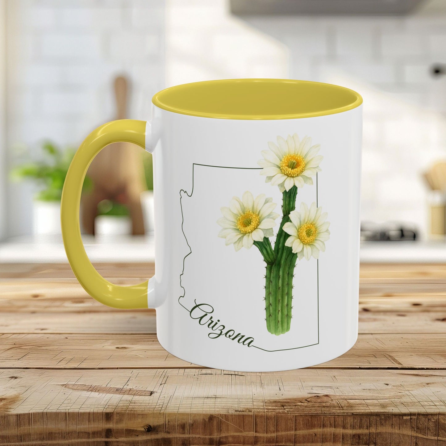 White ceramic mug with yellow handle and interior, featuring an Arizona outline and blooming saguaro cactus.