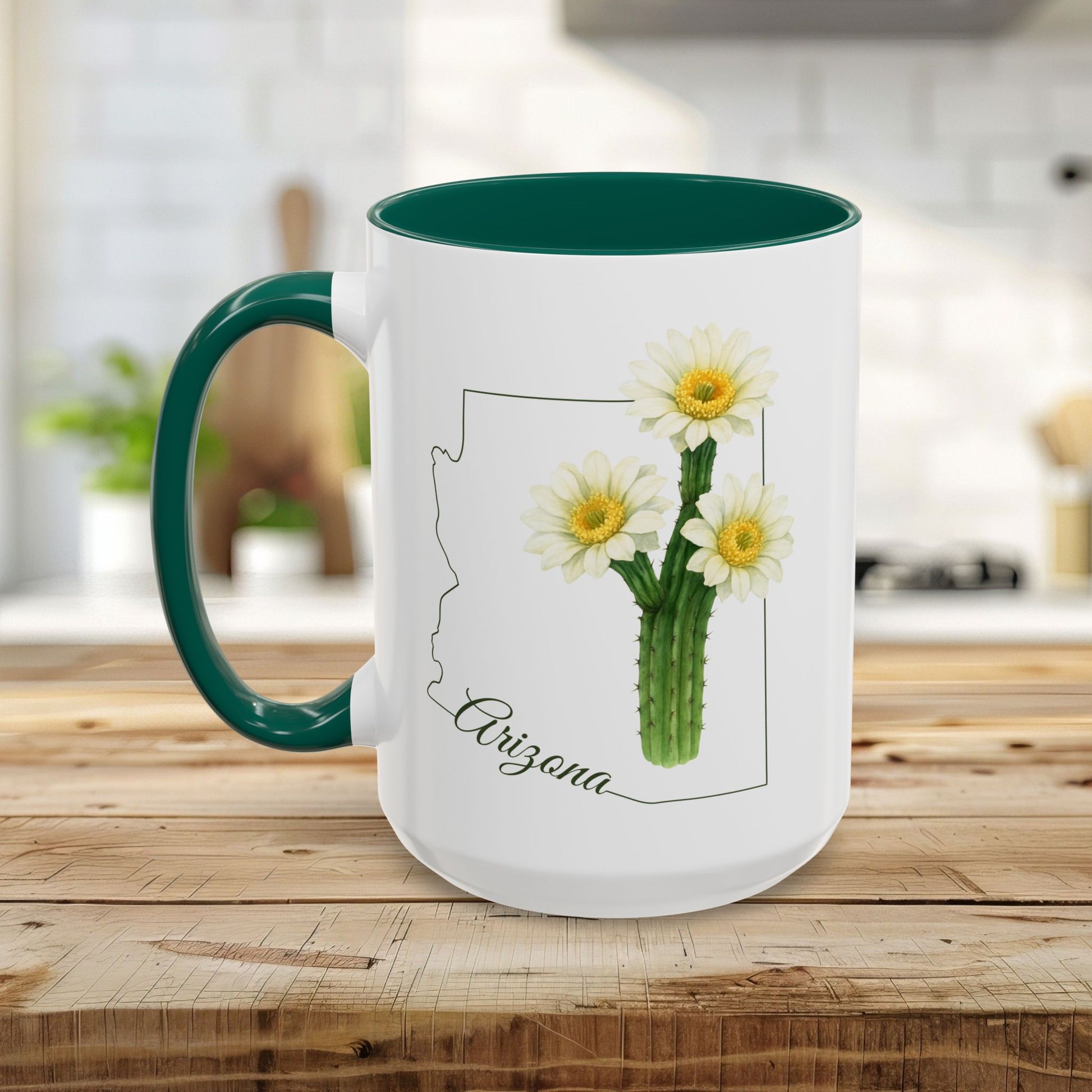 White ceramic mug with green handle and interior, featuring an Arizona outline and blooming saguaro cactus.