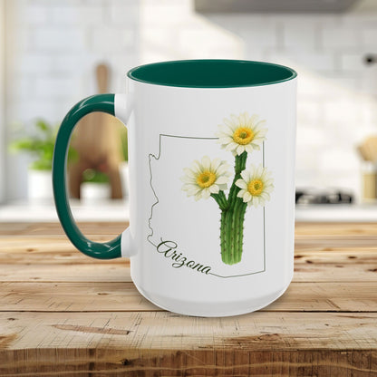 White ceramic mug with green handle and interior, featuring an Arizona outline and blooming saguaro cactus.
