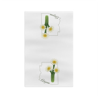 White microfiber tea towel with two saguaro cactus blooms, Arizona state outline, and cursive "Arizona" text.