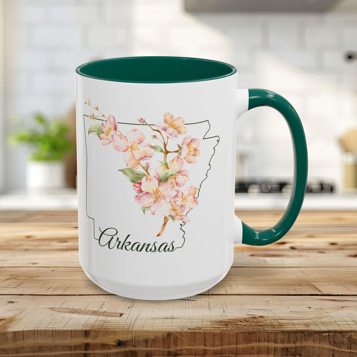 15oz white ceramic mug with green handle and interior, featuring watercolor apple blossoms over an Arkansas outline.