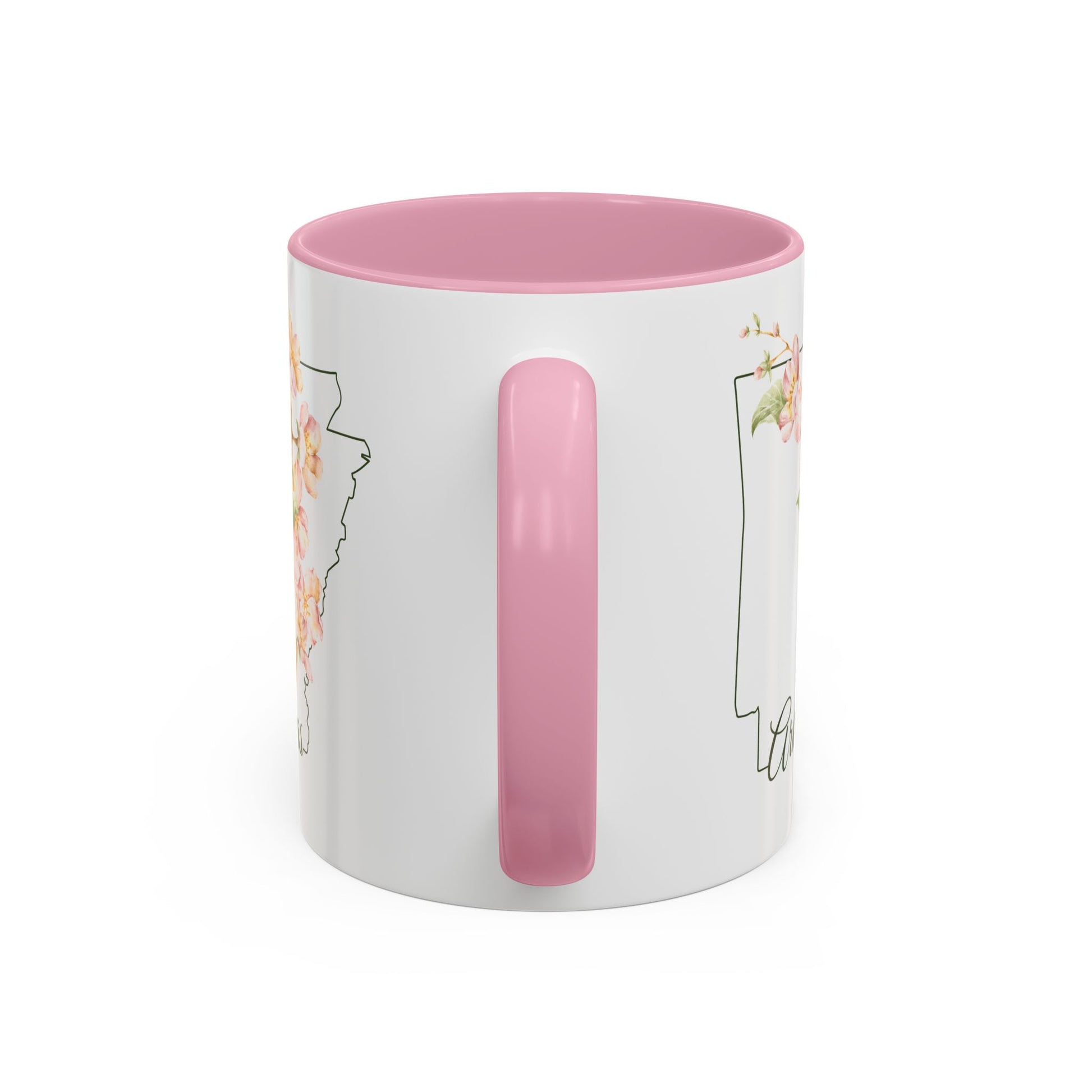 White ceramic mug with pink handle and interior, featuring a watercolor apple blossom design over an Arkansas outline.