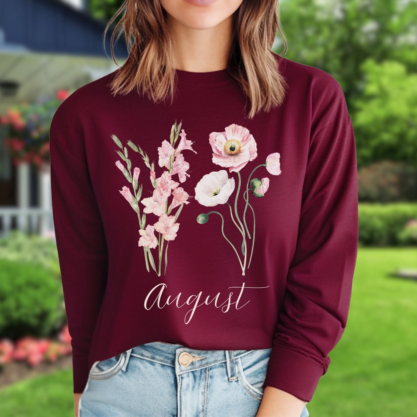 Maroon long-sleeve tee with watercolor gladiolus and poppy flowers, plus "August" script.