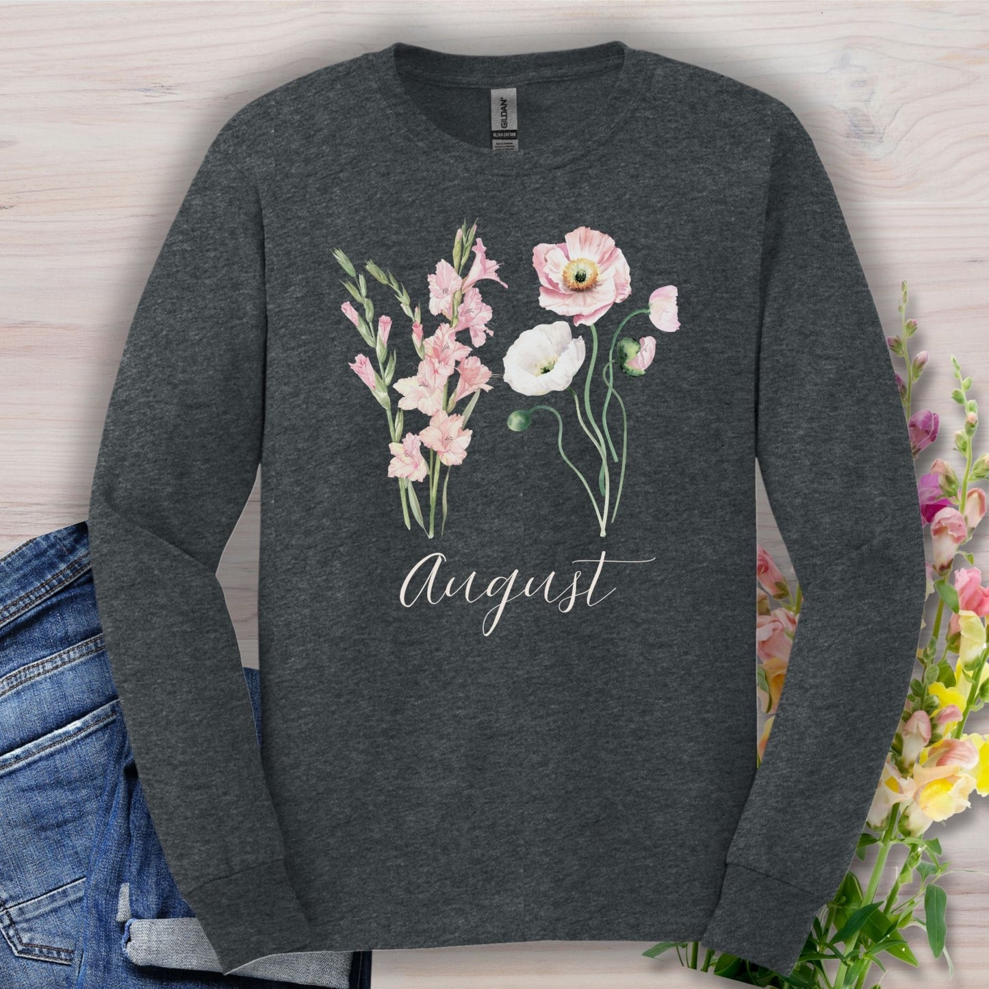 Dark Heather long-sleeve tee with watercolor gladiolus and poppy blooms, "August" script, and classic fit.