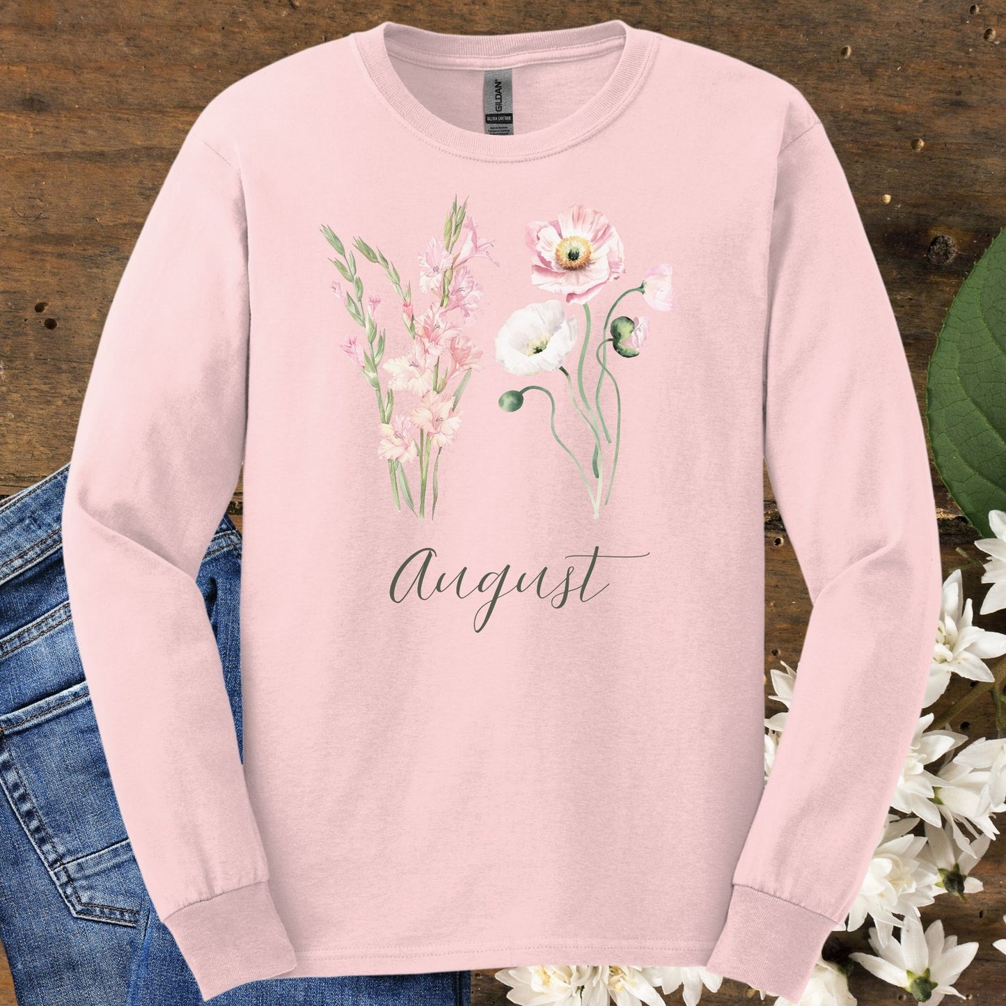 Light pink long-sleeve tee with watercolor gladiolus and poppy flowers, plus "August" script.