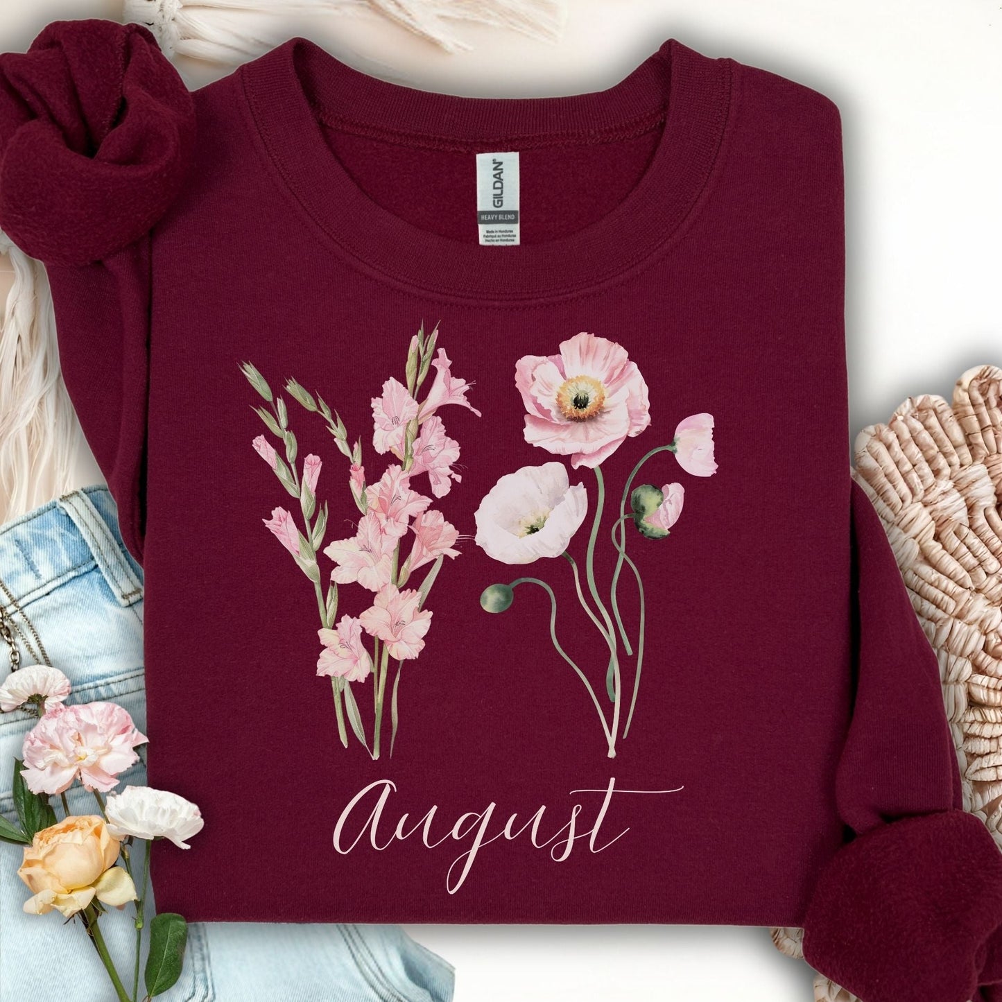 Maroon cotton-poly sweatshirt with watercolor gladiolus and poppy flowers, plus "August" text.