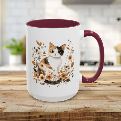 15oz white ceramic mug with maroon interior/handle, featuring a watercolor calico cat surrounded by autumnal florals.