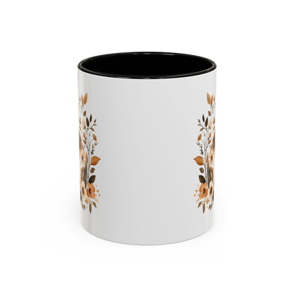 White ceramic mug with black interior and handle, featuring autumnal floral designs on the sides.