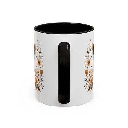 White ceramic mug with black handle and interior, featuring autumnal floral design.