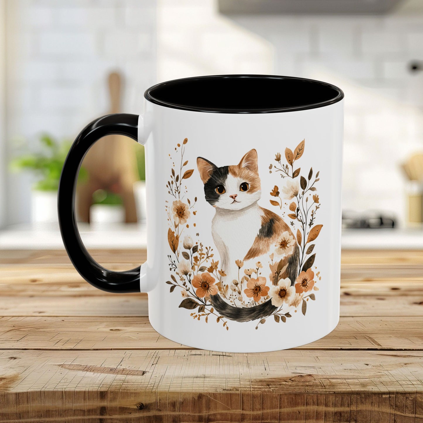 White ceramic mug with black handle and interior, featuring a watercolor calico cat surrounded by autumnal florals.