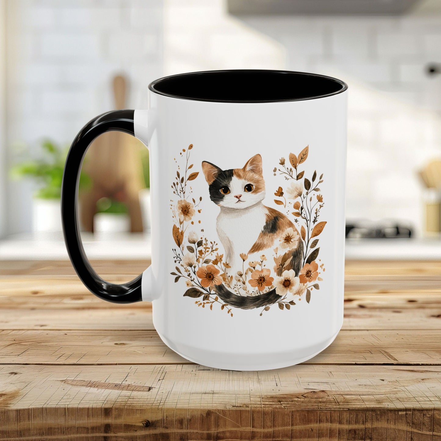 White ceramic mug with a watercolor calico cat surrounded by autumnal florals, black interior and handle.