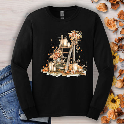 Black long sleeve tee with watercolor autumn lanterns, flowers, and leaves on a rustic ladder.