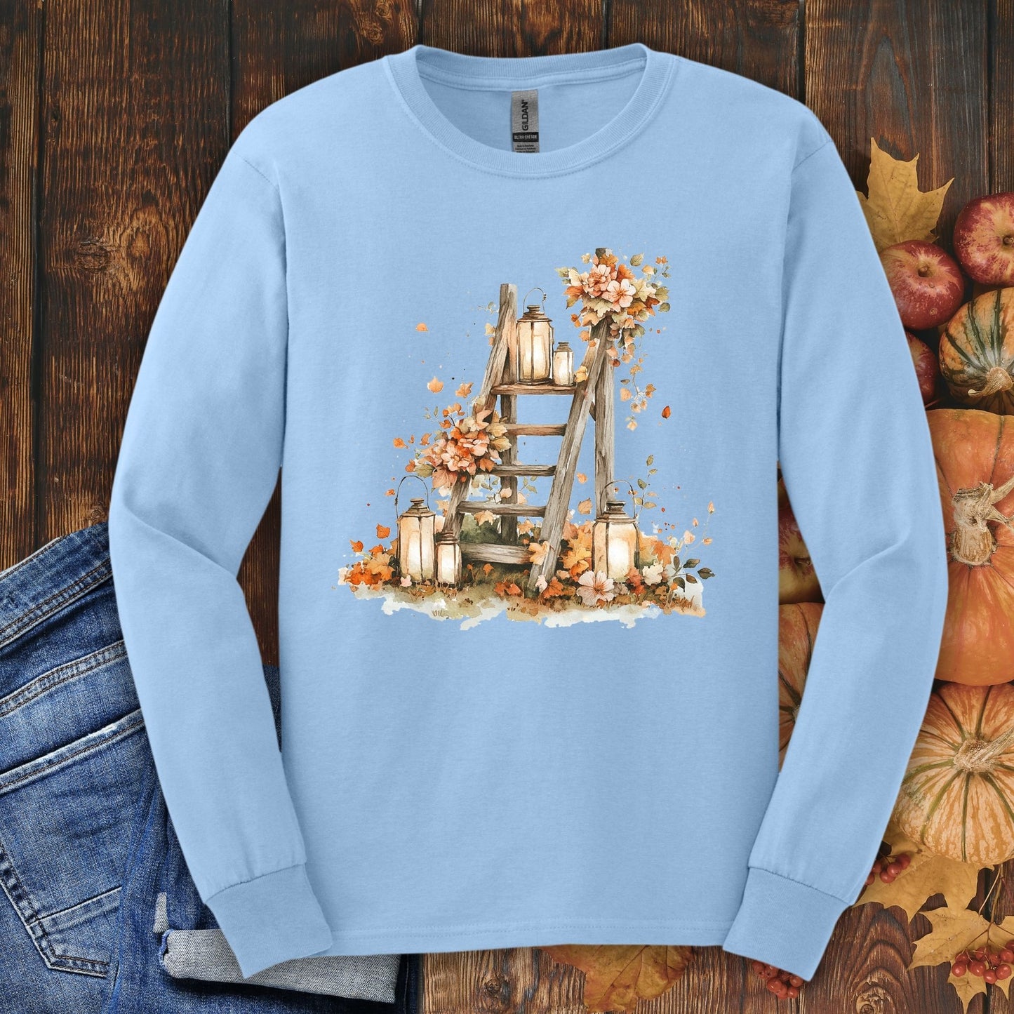 Light blue long sleeve tee with watercolor autumn lanterns, flowers, and a rustic ladder design.