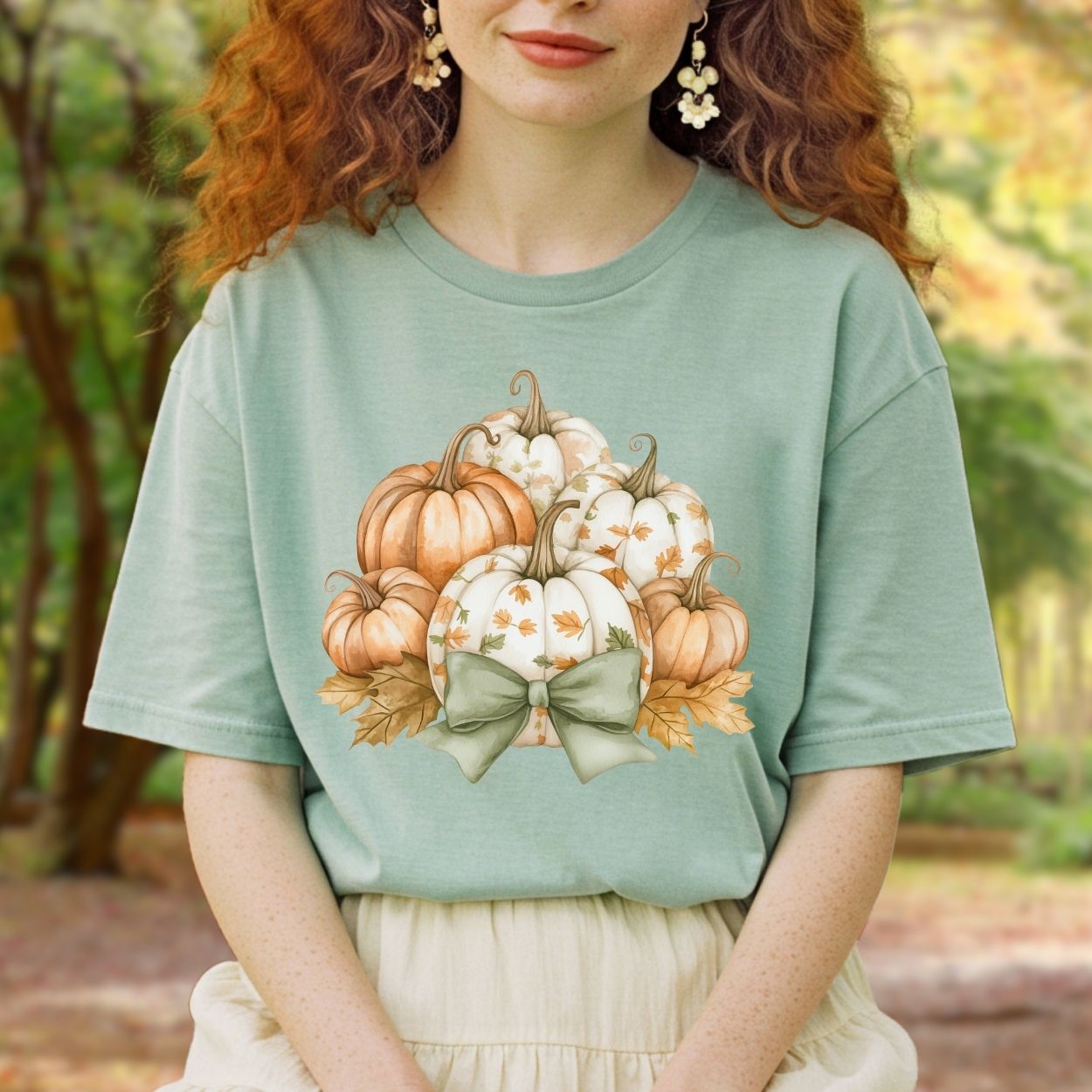 Sage green Comfort Colors tee with watercolor pumpkins, fall leaves, and a sage bow.