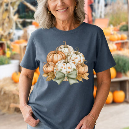 Woman in a charcoal Comfort Colors tee with watercolor pumpkins, autumn leaves, and a sage green bow.