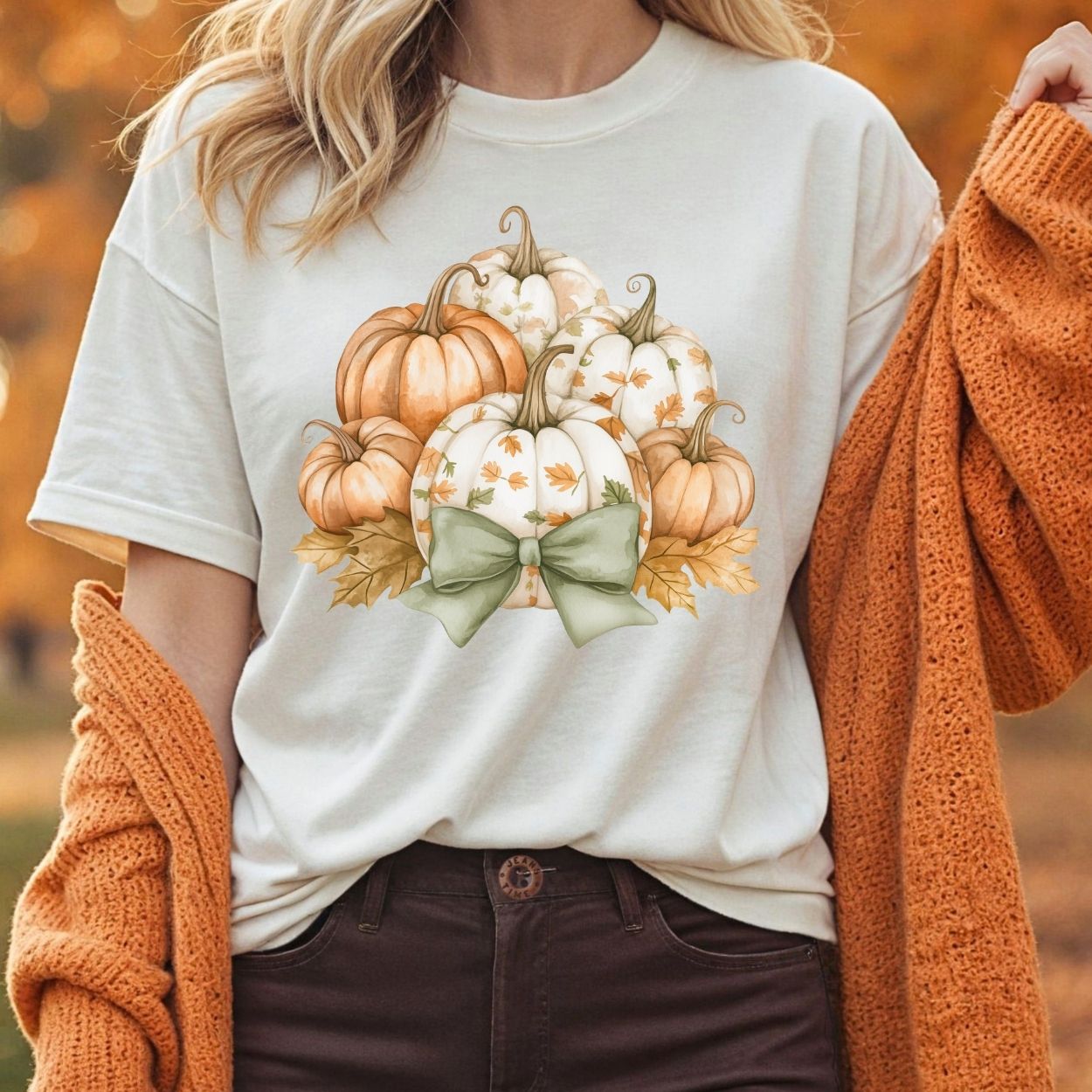 Comfort Colors cream tee with watercolor pumpkins, fall leaves, and a sage green bow.