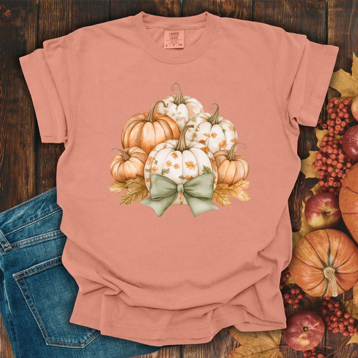 Terracotta Comfort Colors t-shirt with watercolor pumpkins, fall leaves, and a sage green bow.