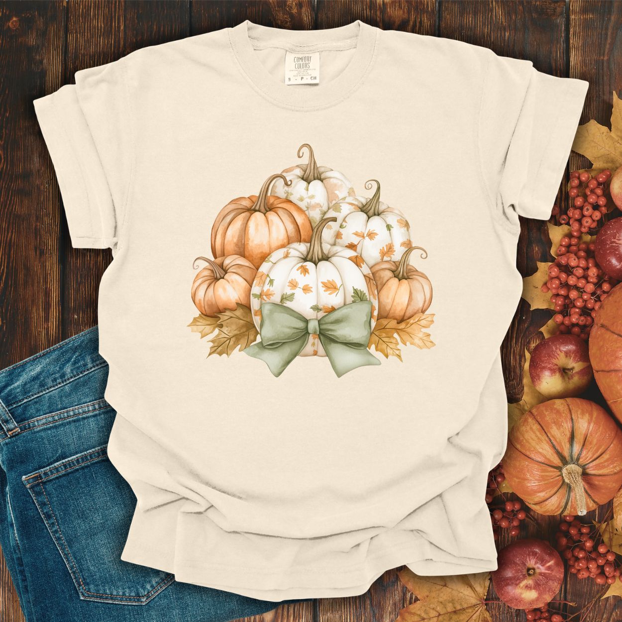 Ivory Comfort Colors tee with watercolor pumpkins, fall leaves, and a sage green bow.
