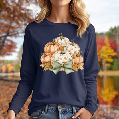 Navy long sleeve tee with a watercolor pumpkin and sage bow design, worn by a woman outdoors in autumn.
