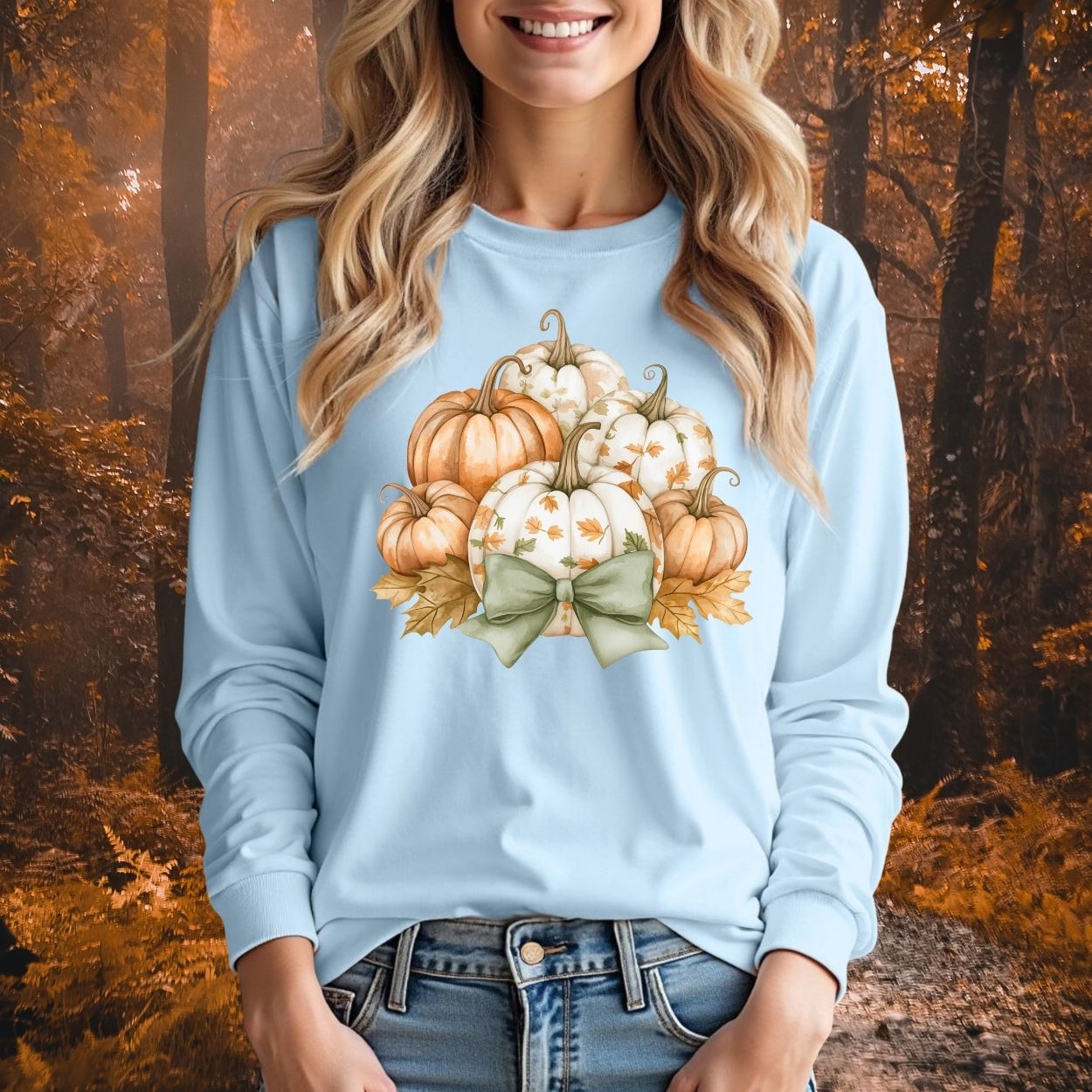 Light blue long-sleeve tee with watercolor pumpkins, terracotta and cream, framed by a sage bow.