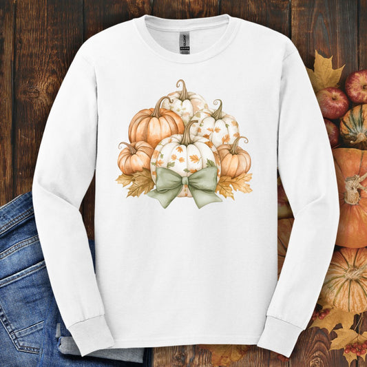 White long-sleeve tee with watercolor terracotta and cream pumpkins, a sage bow, and autumn leaves.