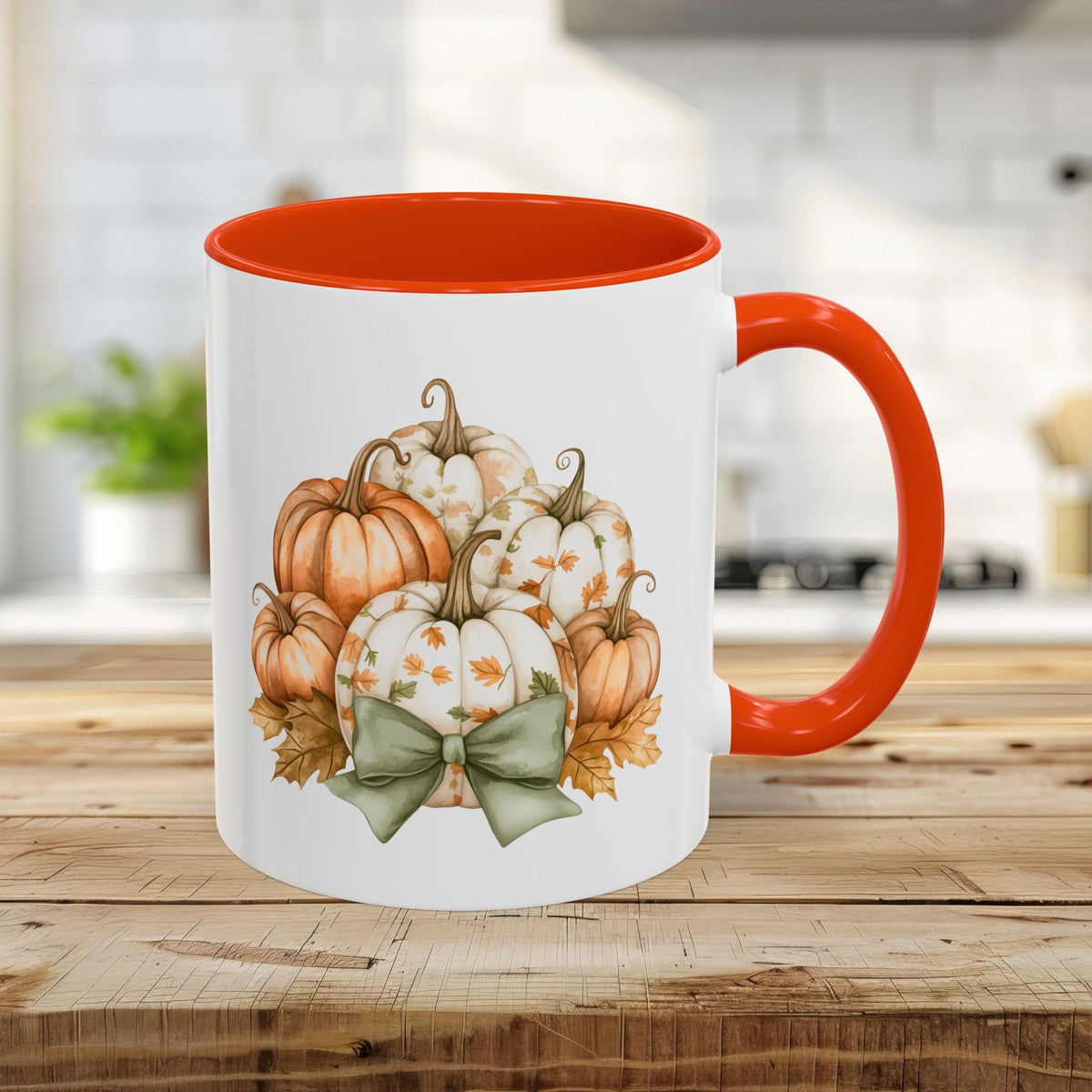 White 11oz ceramic mug with orange interior/handle, featuring a watercolor pumpkin bouquet and green bow.