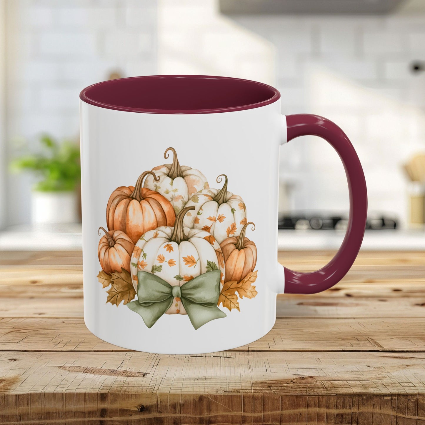 White 11oz ceramic mug with maroon interior/handle, featuring a watercolor pumpkin bouquet and green bow.