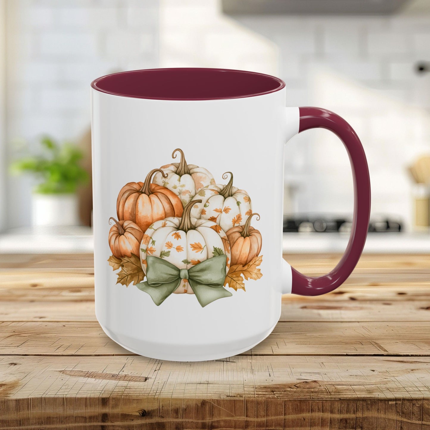15oz white ceramic mug with maroon interior/handle and watercolor autumn pumpkins, foliage, and a green bow.