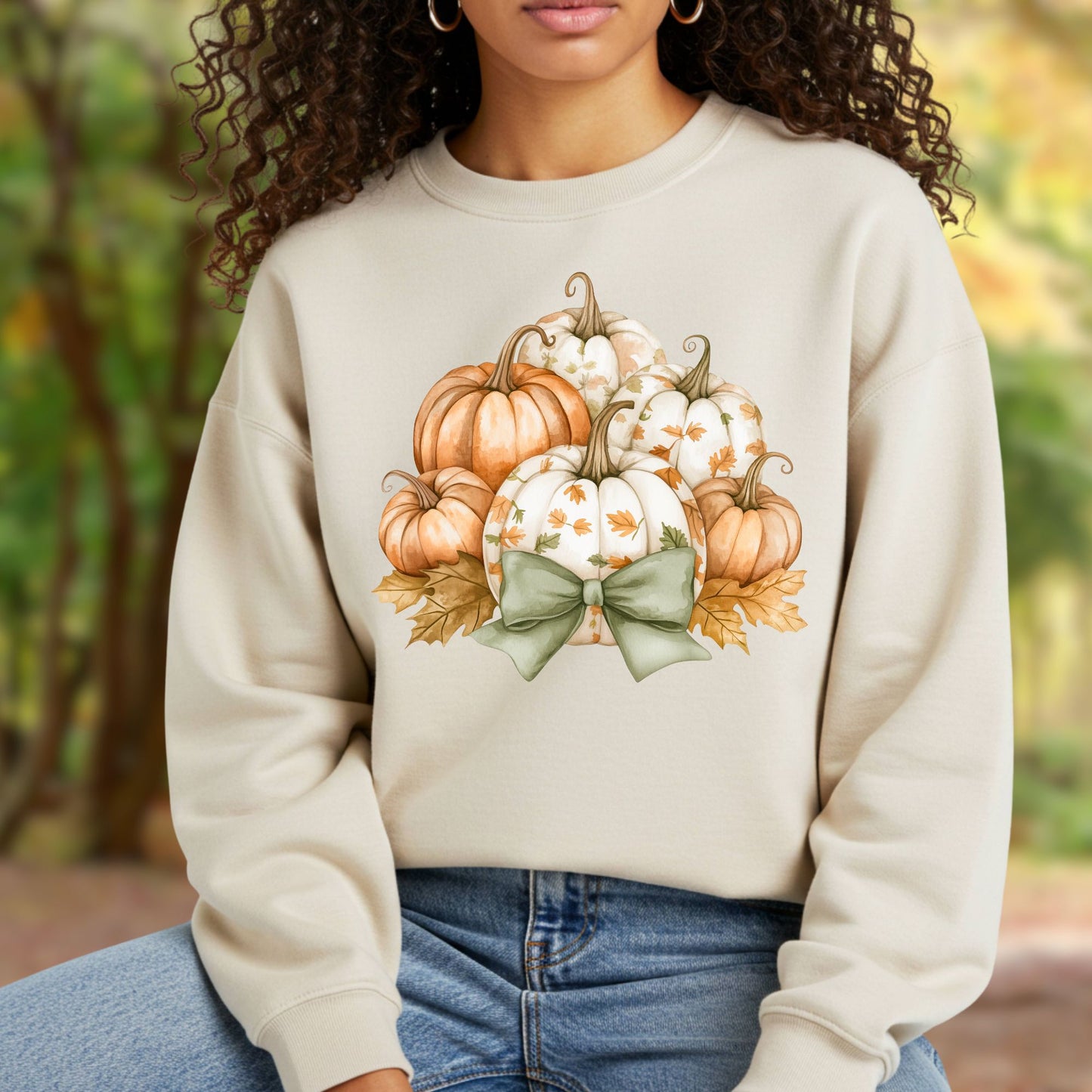 Beige unisex sweatshirt with a cottagecore pumpkin and green bow design.