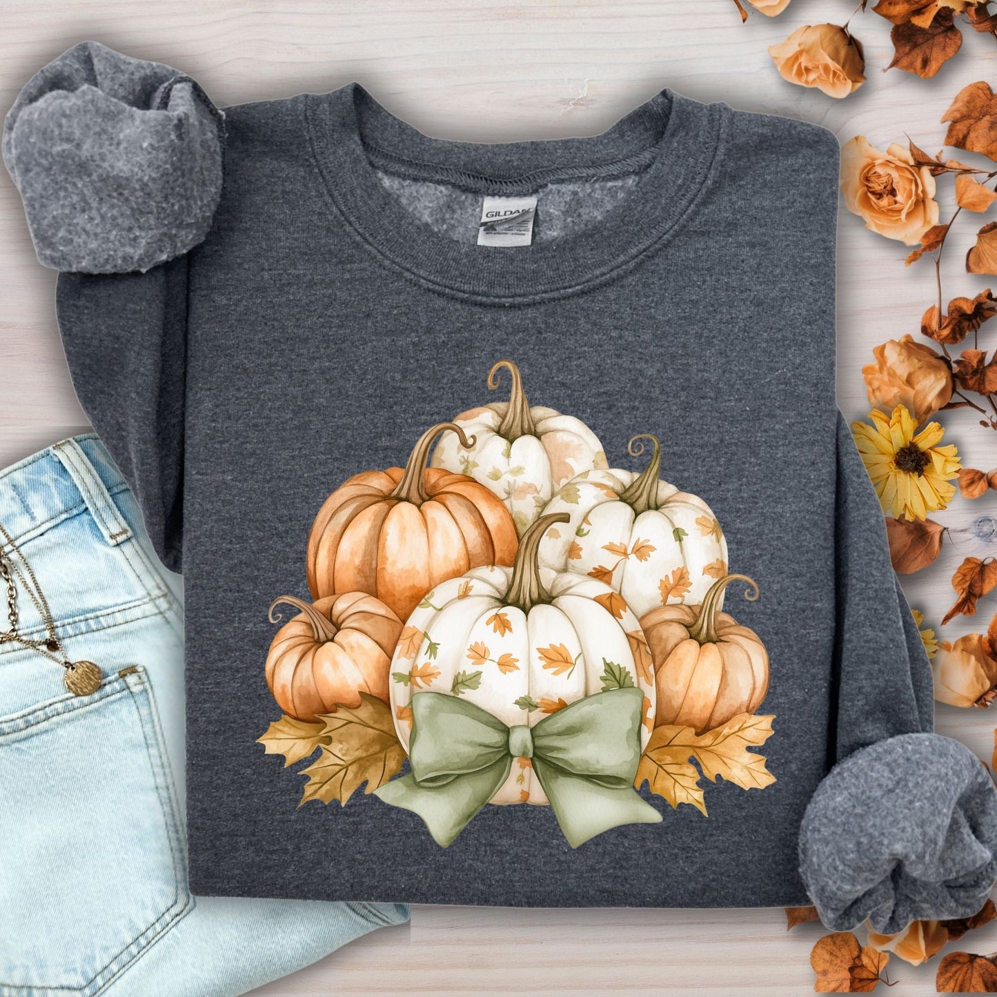 Dark heather Gildan sweatshirt with cottage core pumpkins, green bow, and autumn leaves.