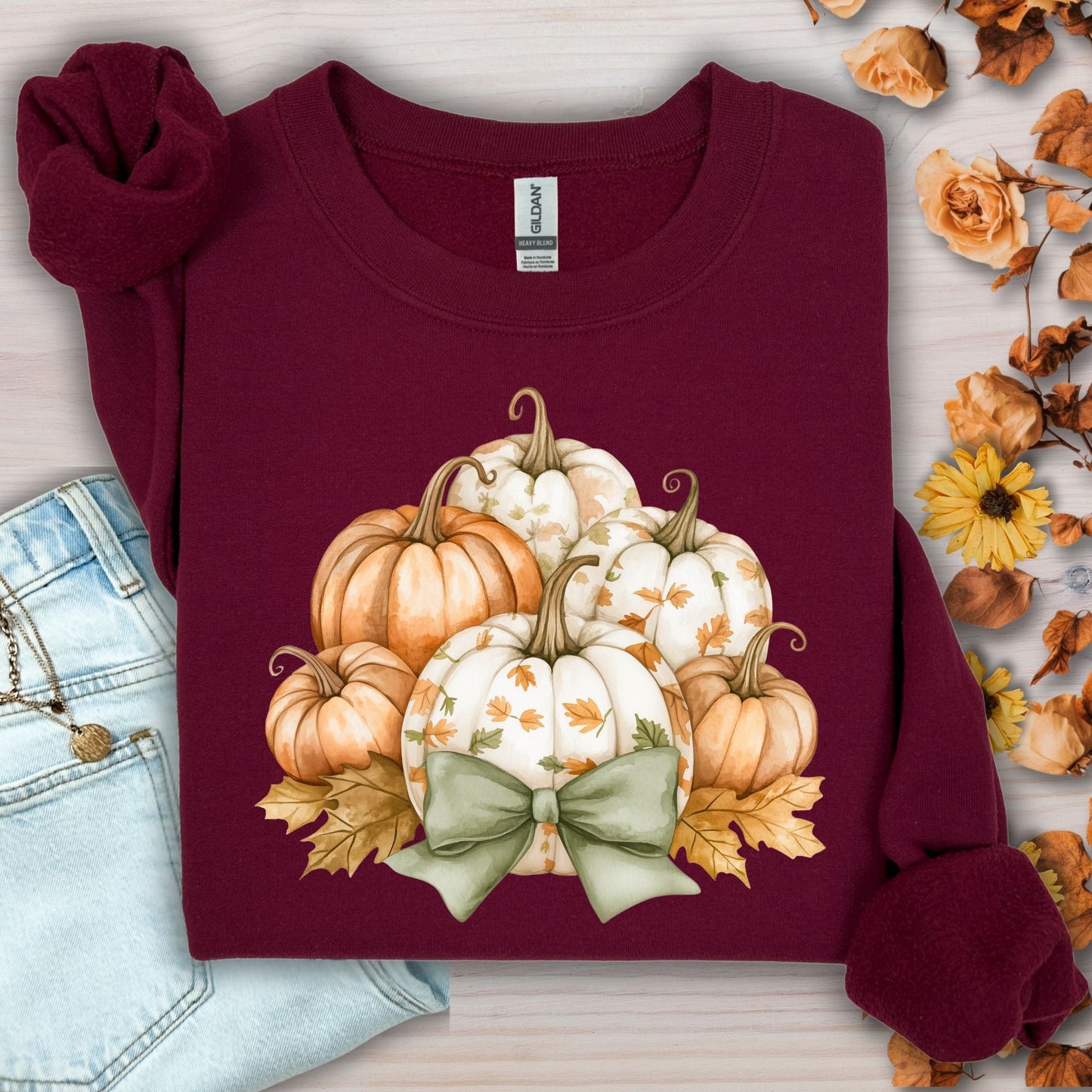 Maroon Gildan cotton-poly blend sweatshirt with cottage core pumpkins, green bow, and autumn leaves design.