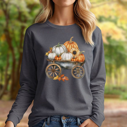 Woman wearing a charcoal long-sleeve tee with a watercolor wagon full of white and orange pumpkins.