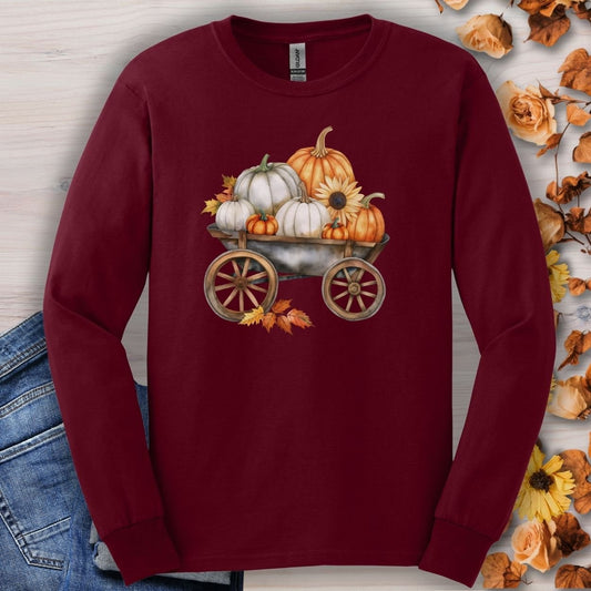 Maroon long-sleeve tee with a watercolor wagon full of white and orange pumpkins and fall leaves.