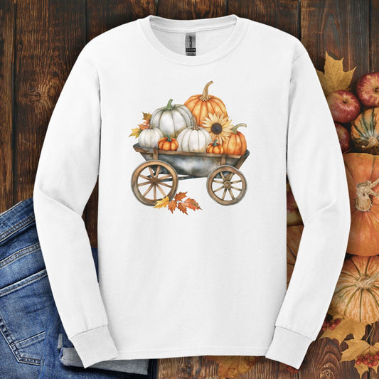 White long-sleeve tee with a watercolor wagon full of white and orange pumpkins and fall leaves.