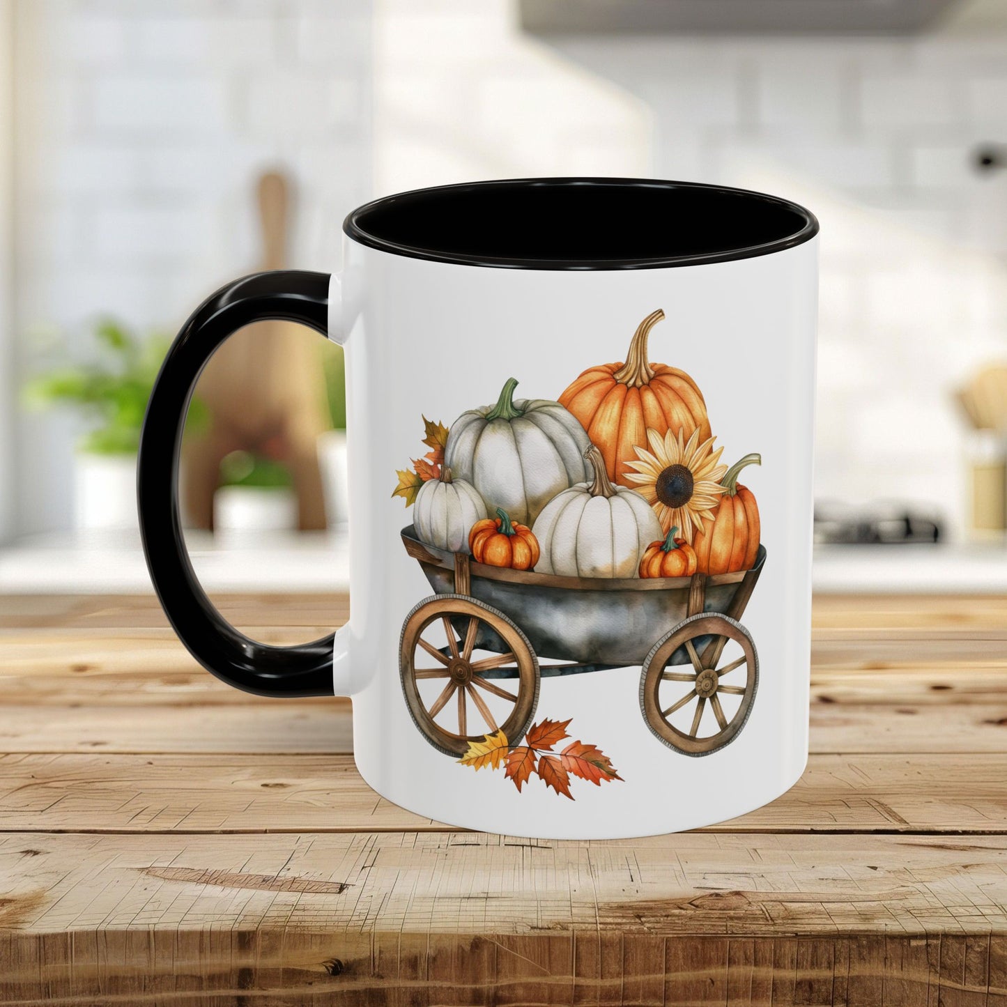 White ceramic mug with black rim and handle, featuring a watercolor-style harvest wagon filled with orange and white pumpkins.