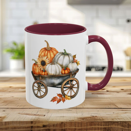 White ceramic 11oz mug with maroon rim and handle, featuring a watercolor autumn pumpkin harvest wagon design.