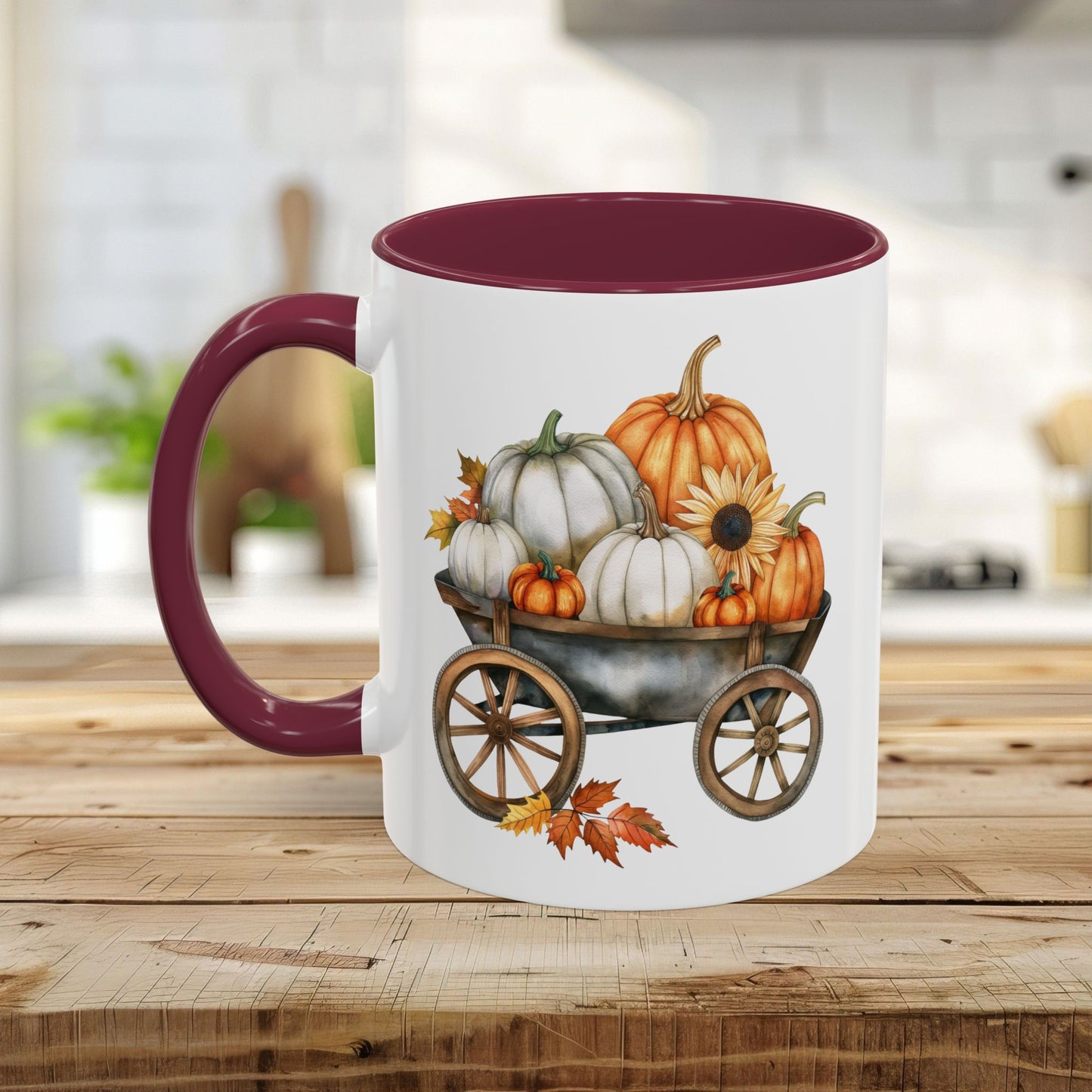 White ceramic mug with a burgundy rim and handle, featuring a watercolor autumn pumpkin harvest wagon design.