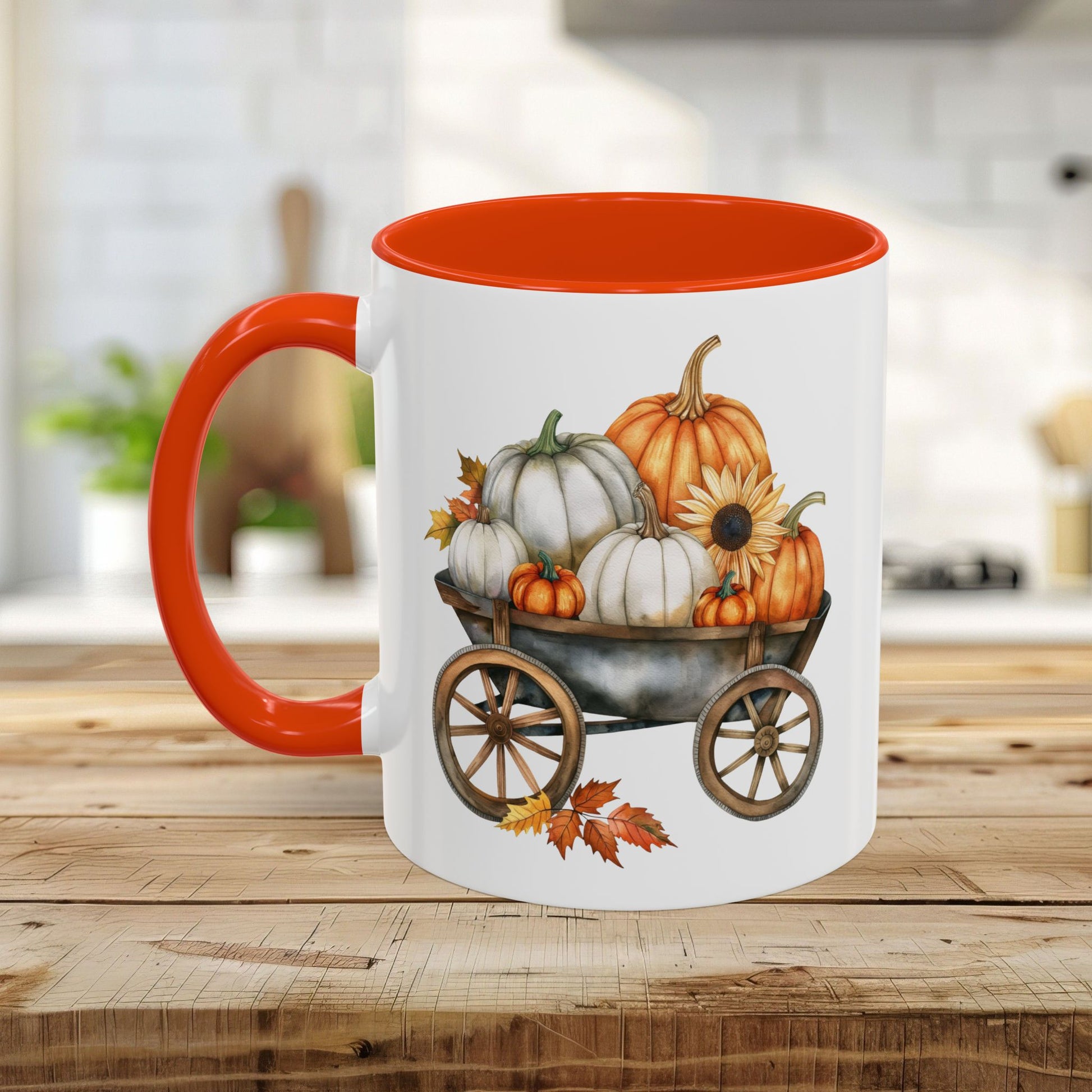White ceramic mug with an orange interior and handle, featuring a watercolor print of pumpkins in a rustic wagon.