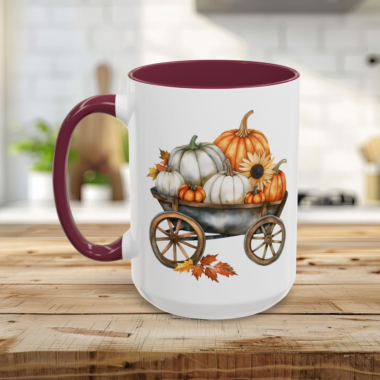 White ceramic mug with a burgundy rim and handle, featuring a watercolor-style autumn wagon filled with pumpkins and a sunflower.