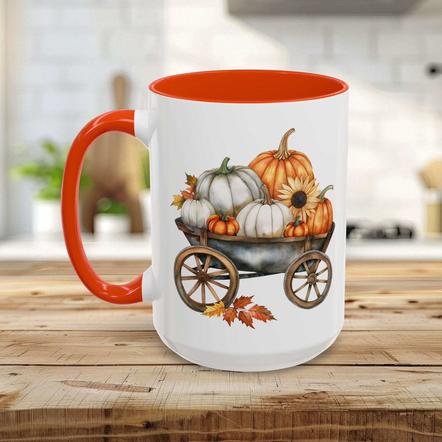 White ceramic mug with an orange handle and interior, featuring a watercolor print of pumpkins in a rustic wagon.