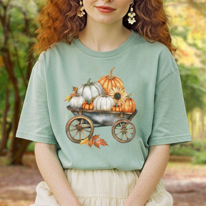 Garment-dyed, relaxed-fit t-shirt in sage green with a watercolor pumpkin harvest wagon design.
