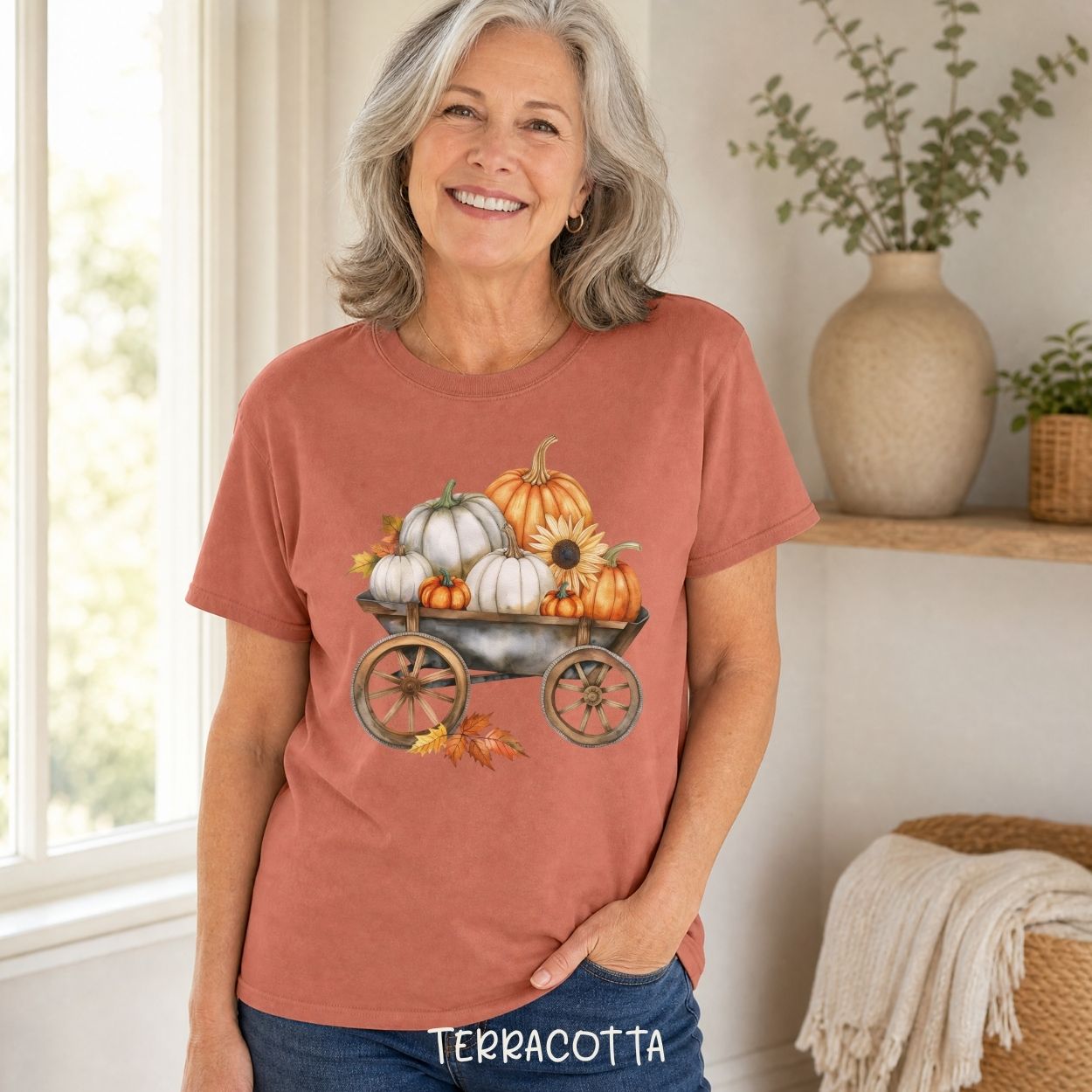 Terracotta garment-dyed t-shirt with a watercolor rustic wagon piled with white and orange pumpkins and sunflowers.