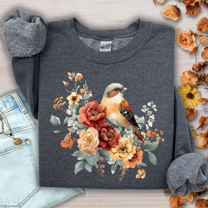 Dark Heather Gildan sweatshirt with watercolor sparrow and autumn roses, folded on a wooden surface.