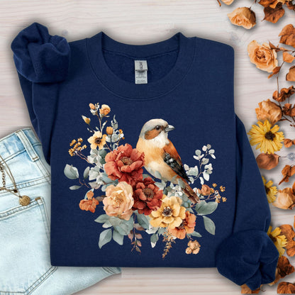 Navy Gildan crewneck sweatshirt with watercolor sparrow and autumn roses, next to jeans and fall leaves.
