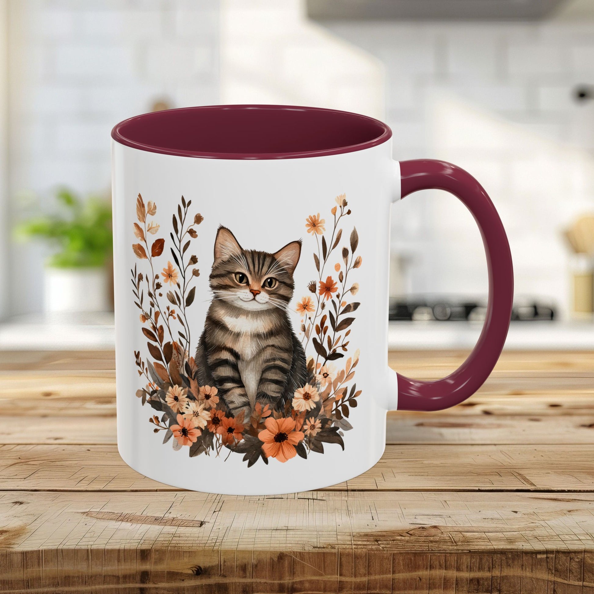Autumn Striped Cat with Wildflowers 11oz ceramic mug, featuring a tabby kitten and burnt orange florals, with a maroon interior and handle.